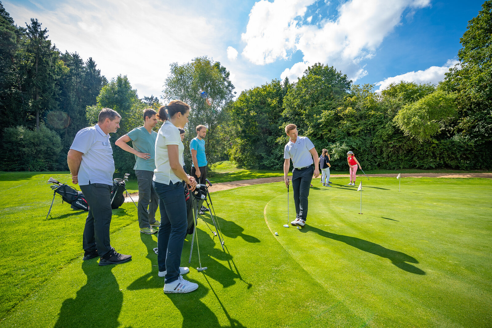 Eine Lerngruppe arbeitet gemeinsam auf dem Putting Green.