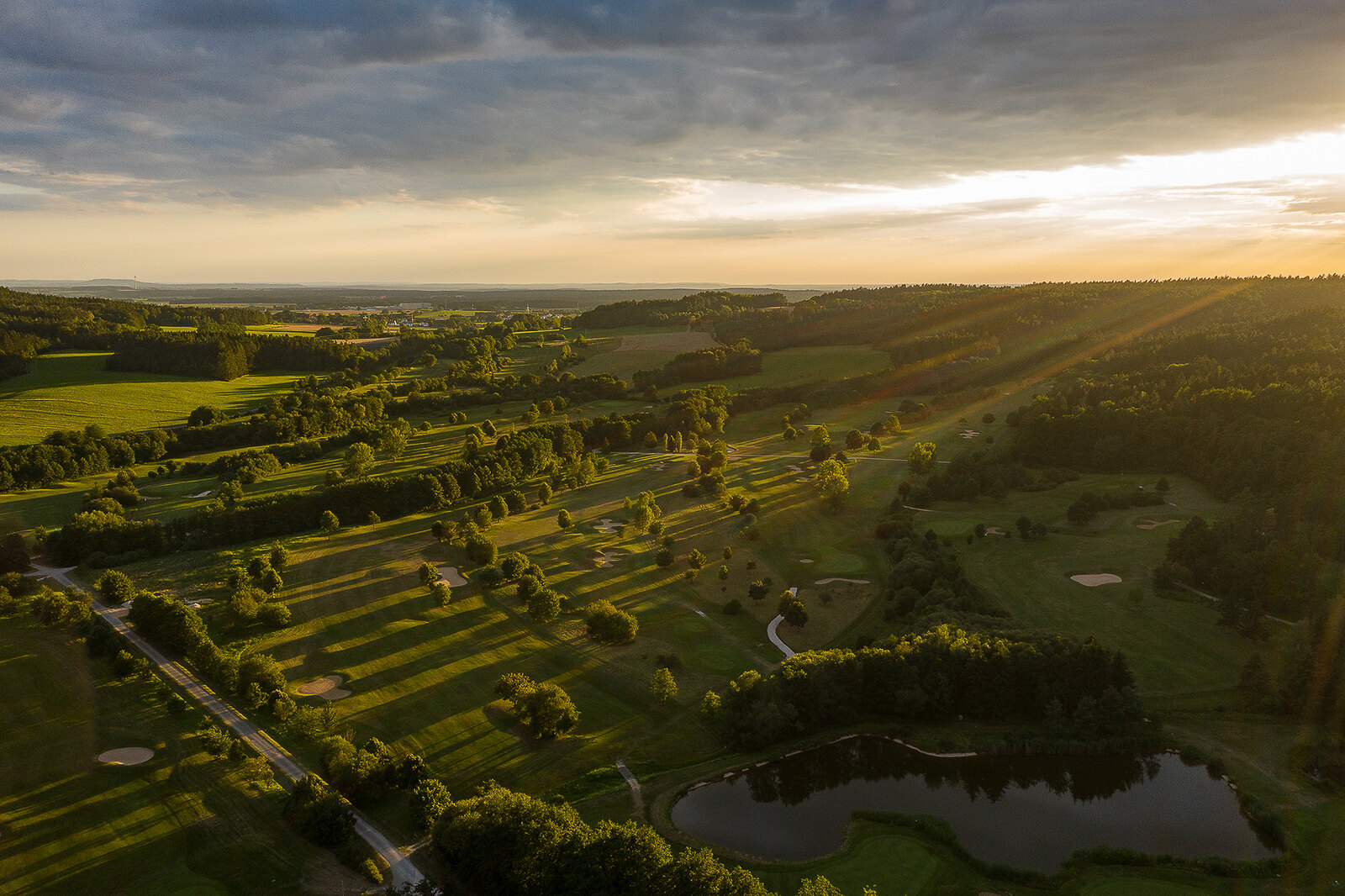 Luftaufnahme einer Golfanlage im Abendlicht.
