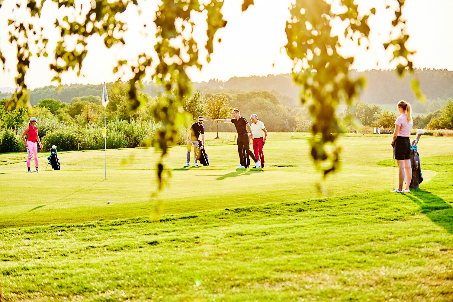 Eine Gruppe spielt gemeinsam auf einem Putting Green.